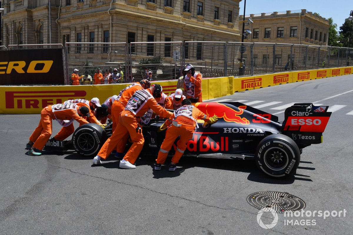 Marshals move the damaged car of Max Verstappen, Red Bull Racing RB16B
