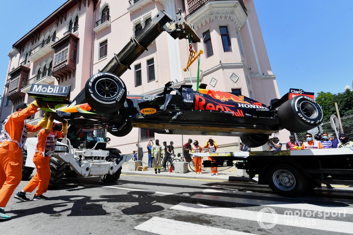 Marshals move the damaged car of Max Verstappen, Red Bull Racing RB16B
