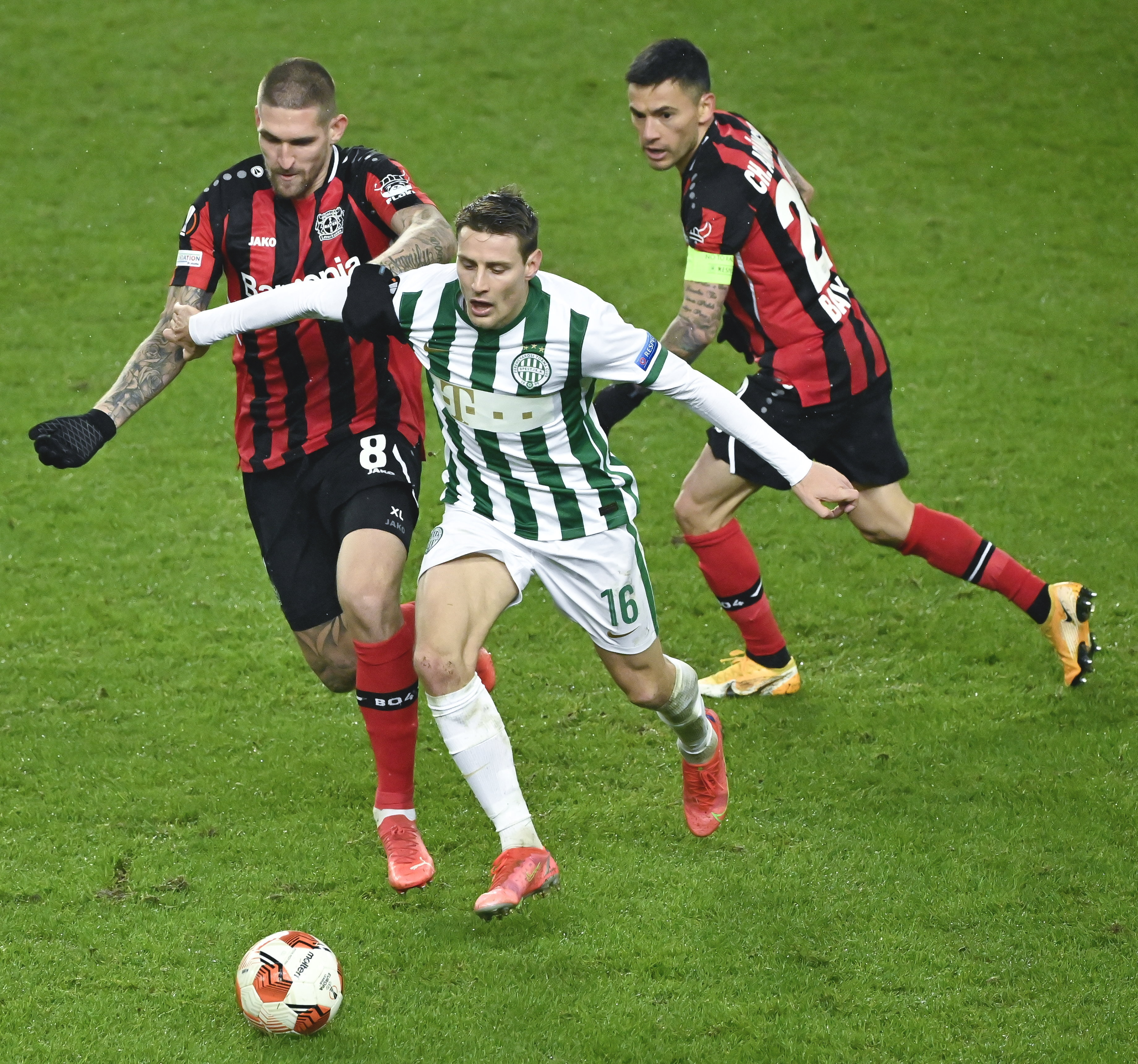 A képen: A ferencvárosi Kristoffer Zachariassen (k), valamint Robert Andrich (b) és Charles Aránguiz (j), a Bayer Leverkusen játékosa az Európa-liga csoportkörében, a G csoport hatodik fordulójában játszott mérkőzésen a Groupama Arénában 2021. december 9-én. Ferencváros-Bayer Leverkusen 1-0. MTI/Koszticsák Szilárd